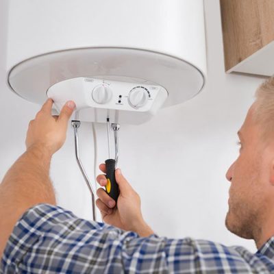 Chauffagiste raccorde les tyaux de la chaudière